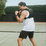 Two people practicing boxing on a tennis court.
